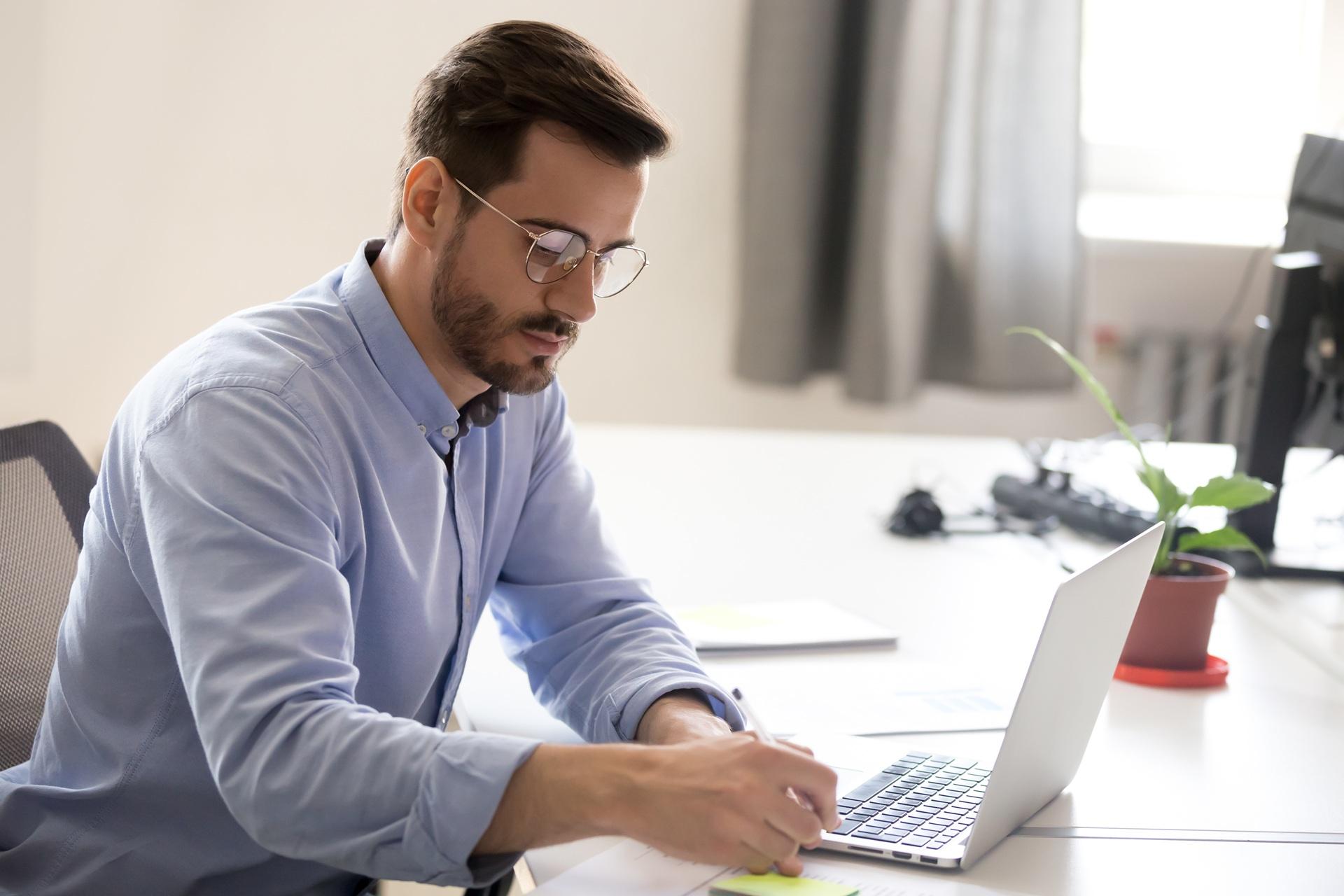 Mann schreibt konzentriert am Laptop | Ghostwriter Bachelorarbeit