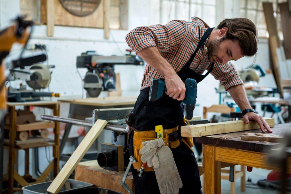 Handwerker arbeitet mit Bohrmaschine an Holzbrettern | Landwirtschaft Stellenangebote